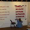 Marcia paints a stenciled quote onto the wall.